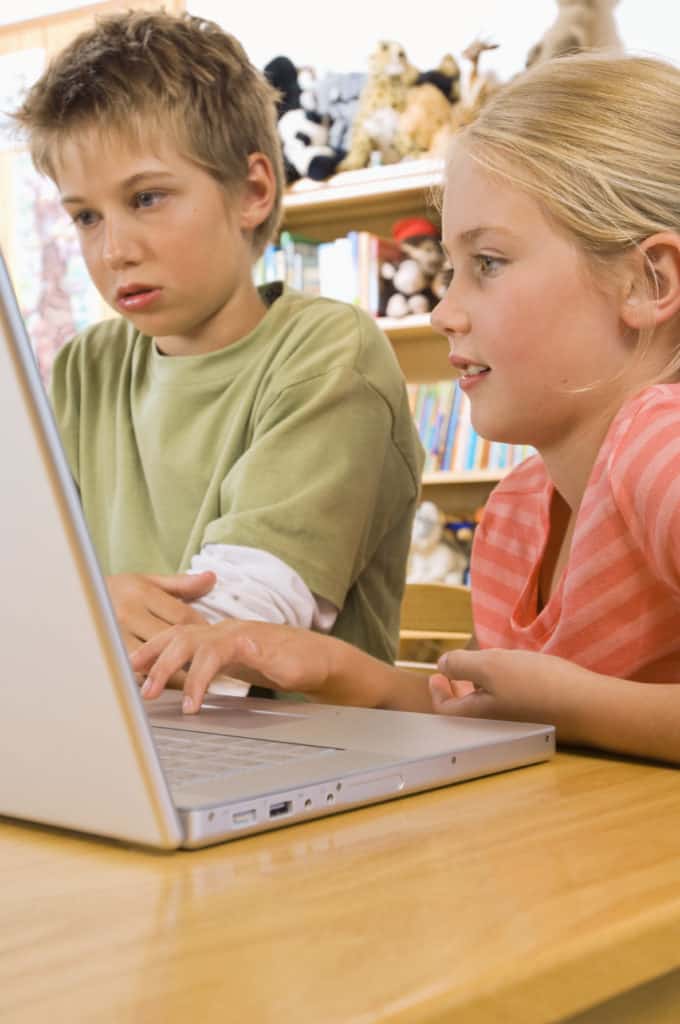 Two elementary students using a laptop at school