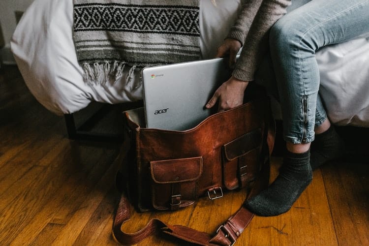 Person storing their laptop in a bag