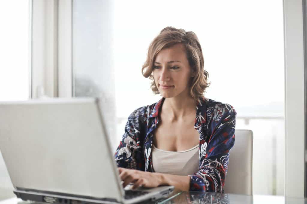 Woman sitting while using while a laptop