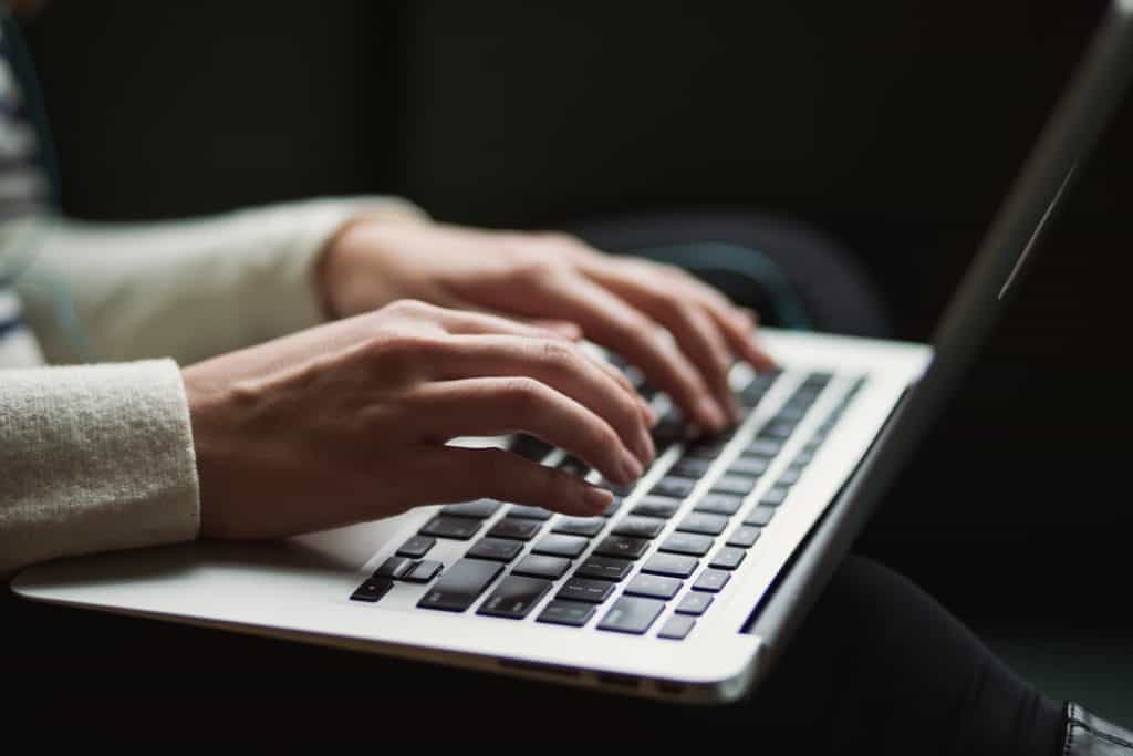 A person typing on a laptop keyboard