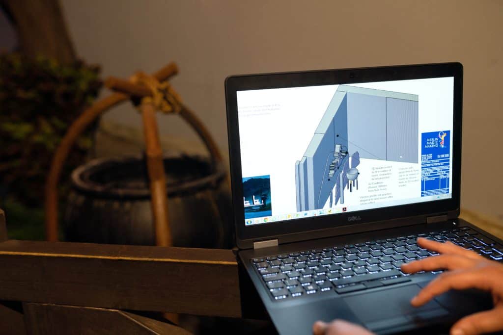 Person using SketchUp on a laptop to create a 3D diagram for a project
