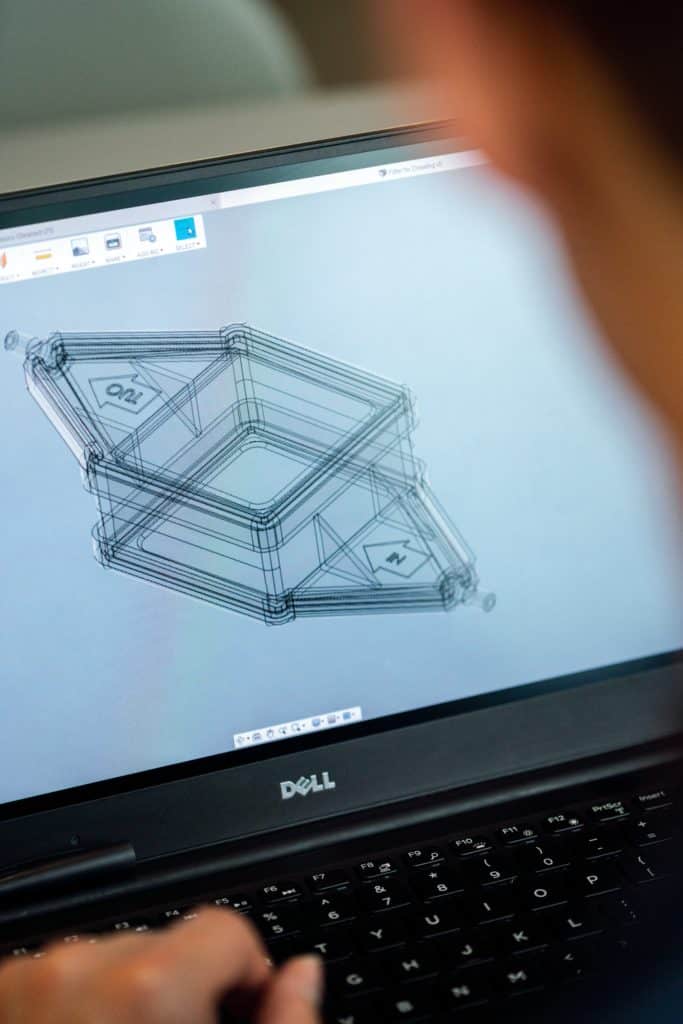 Person drawing a 3D diagram on a laptop