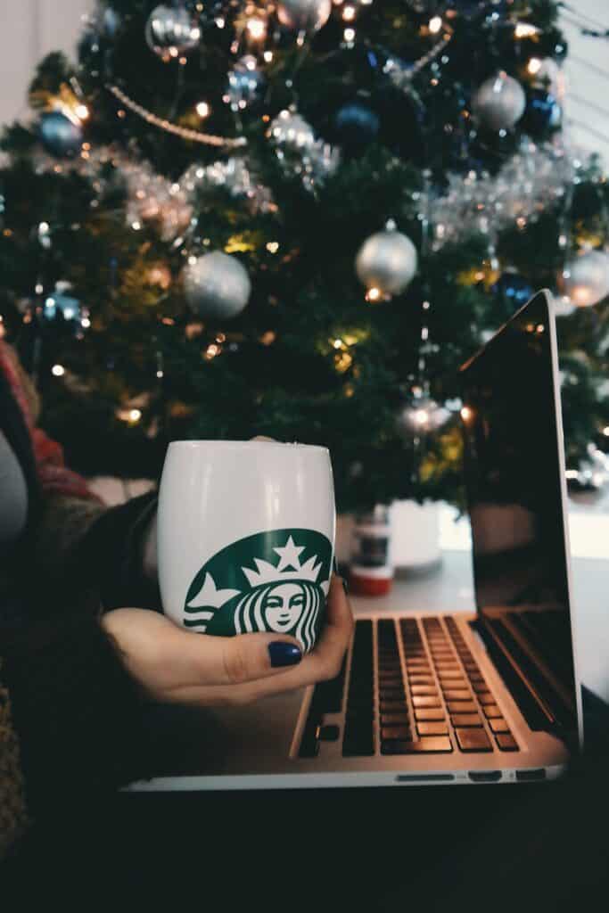 Woman holding a mug while using her laptop